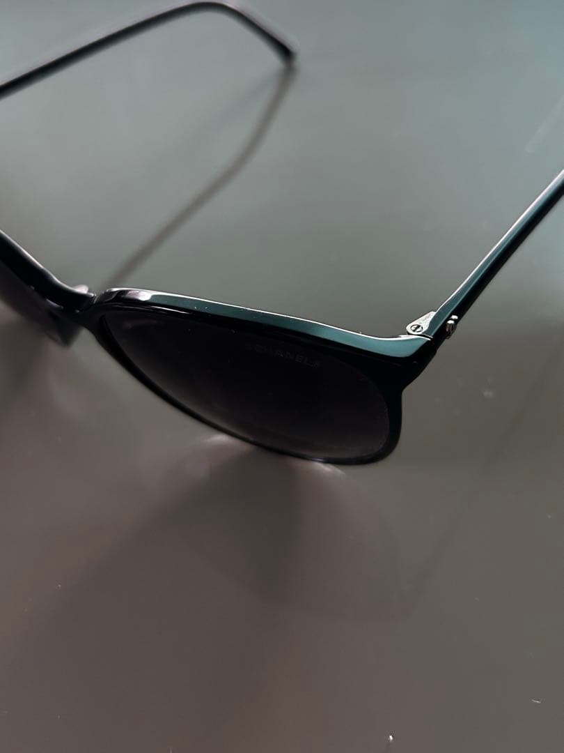 ブラックのCHANELサングラス、ケース、内袋、ロゴ付き。