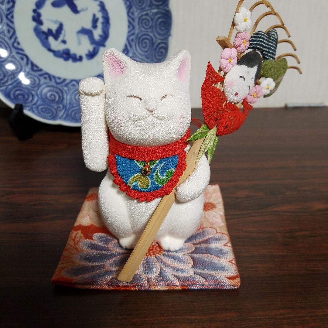 くまでを持った招き猫